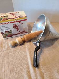 lot 2105 image: Aluminum colander cone sieve strainer with 11 inch vintage wooden pestle masher and an apple peeler.