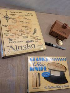 lot 2162 image: Alaska Ulu knife with stand, small Alaska wooden cabin with incense inside, Alaska photo album