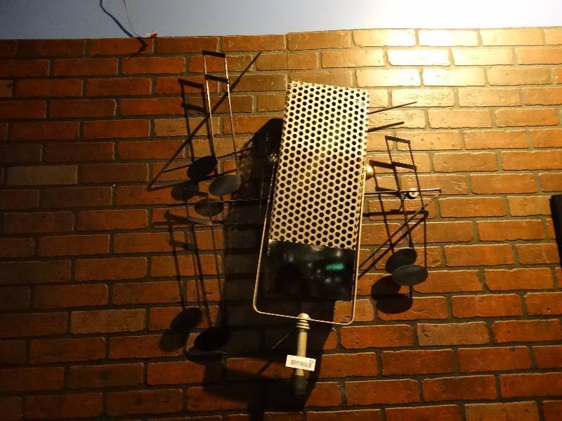 lot 506 image: Metal microphone wall art by C Jere dated 1995.