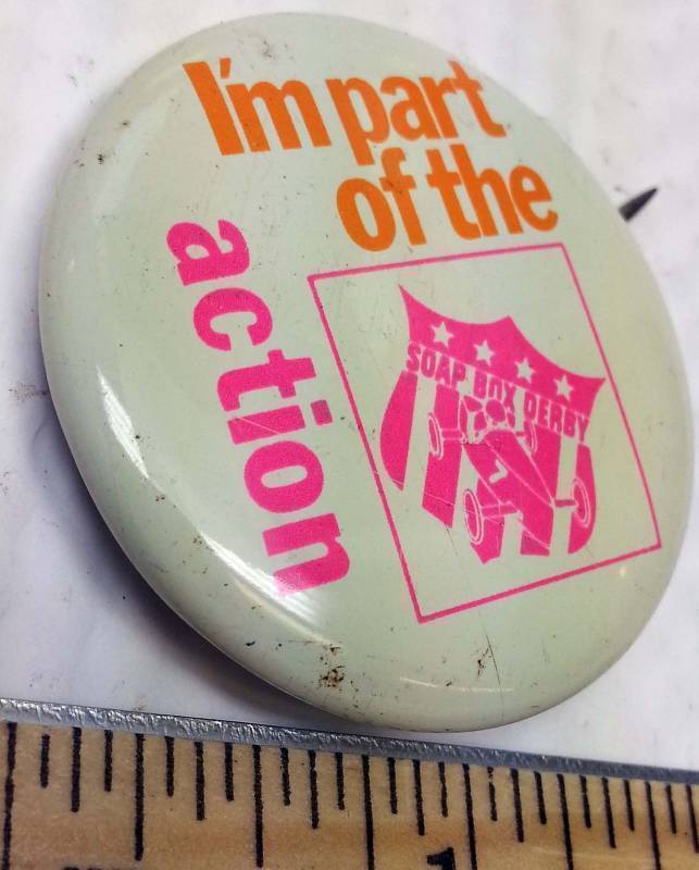lot 8861 image: Im part of the action Soap Box Derby hat pin Pink and Orange with SBD logo Out of a collectors jewelry box.