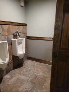 lot 81625 image: Partial Contents of Mens Bathroom, Including Doors, 2 Urinals, Light Fixture, Toilets, Granite And Faucets
