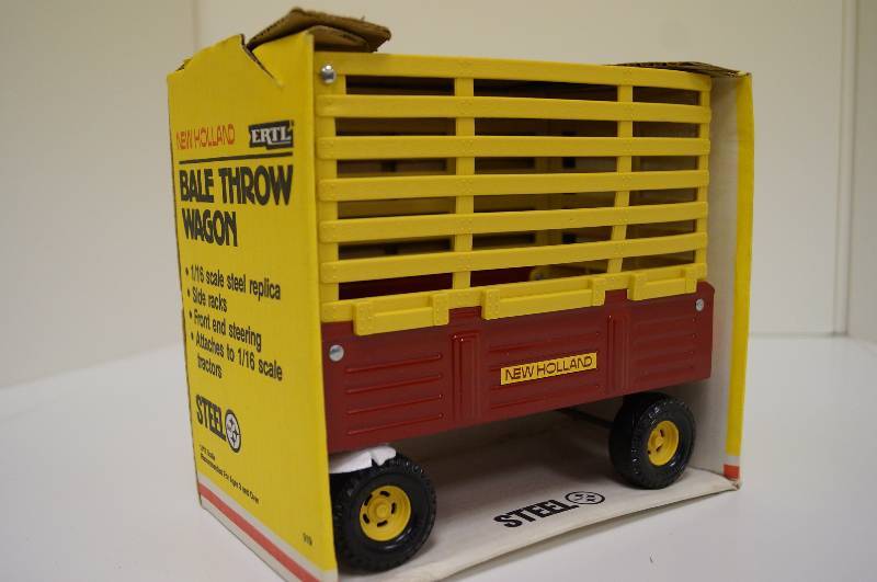 lot 1659 image: ERTL New Holland Bale Throw Wagon, 116,slide racks, front steering, NIB