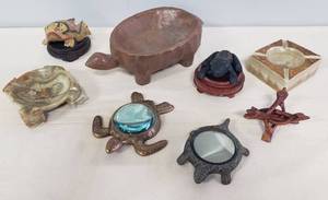 lot 111 image: Carved Wood Turtle Console Bowl, Brass & Bronze Metal Framed Table Magnifying Glasses, Wood Display Stands, Carved Wood Link Crystal Display Stand, Carved Wood Hand Painted Frog, Cast Iron Painted Frog Box, & 2 Cut Marble Ashtrays