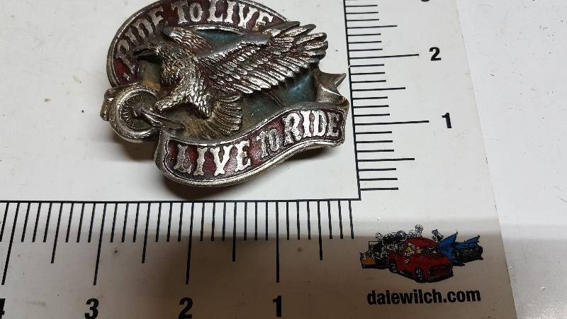 lot 5884 image: Live to Ride Ride to Live Silver Belt Buckle with an Eagle on it. Looks to be #1036 with a copyright from 1982