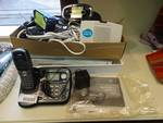 Cordless phone/answering machine, Direct TV box, box of cords, organizer box, metal shelves.