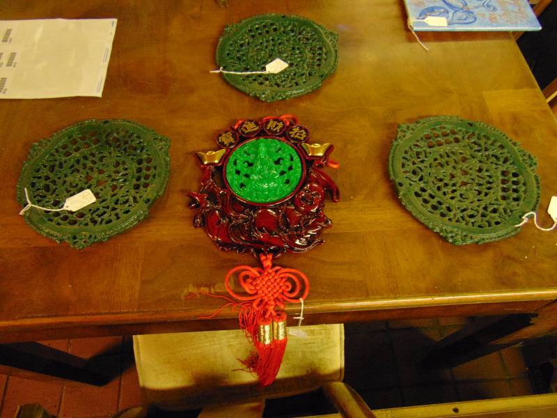 lot 8199 image: Mixed lot (3) decorative wrought iron trivets, (1) hanging Asian art