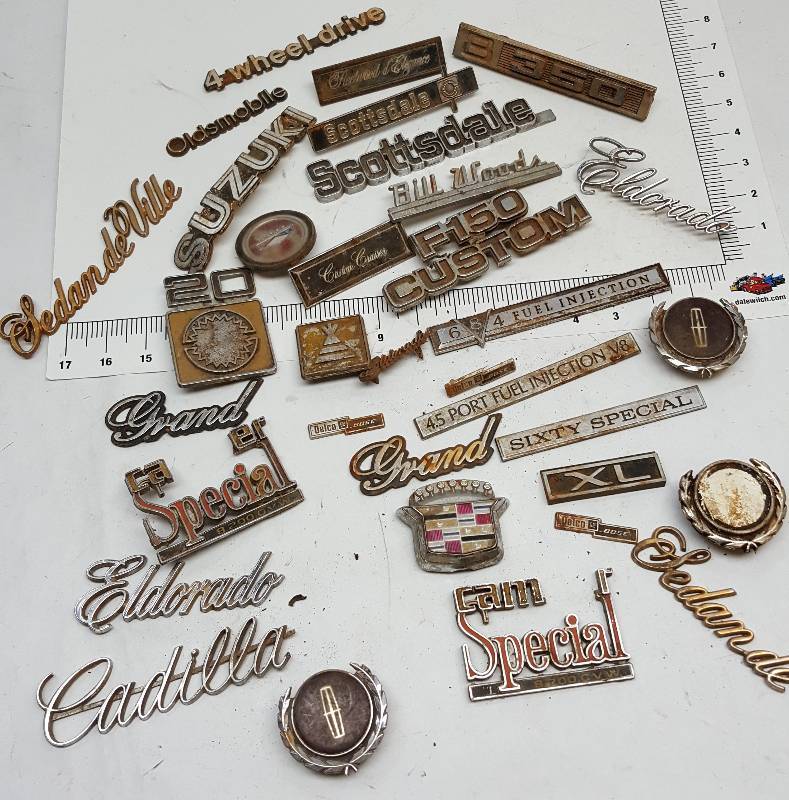 lot 5392 image: Box of assorted car and truck emblems.  Got to be one in here worth the bid