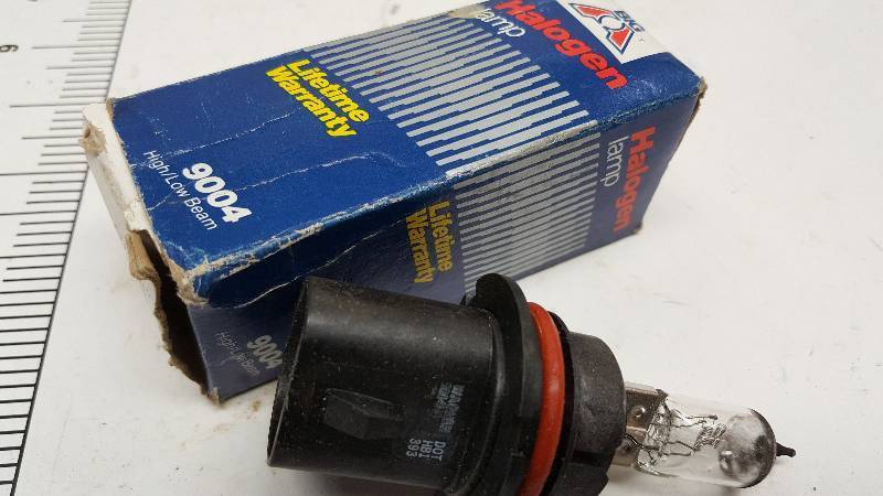 lot 5557 image: Single new Halogen replacement headlight bulb for the common 9004 series bulbs.