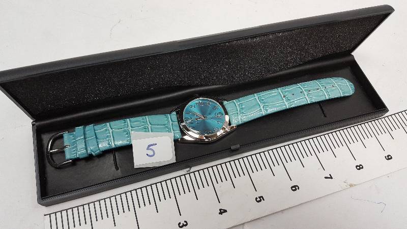 lot 5343-5 image: Cool looking and new in the plastic case is this colored costume watch
