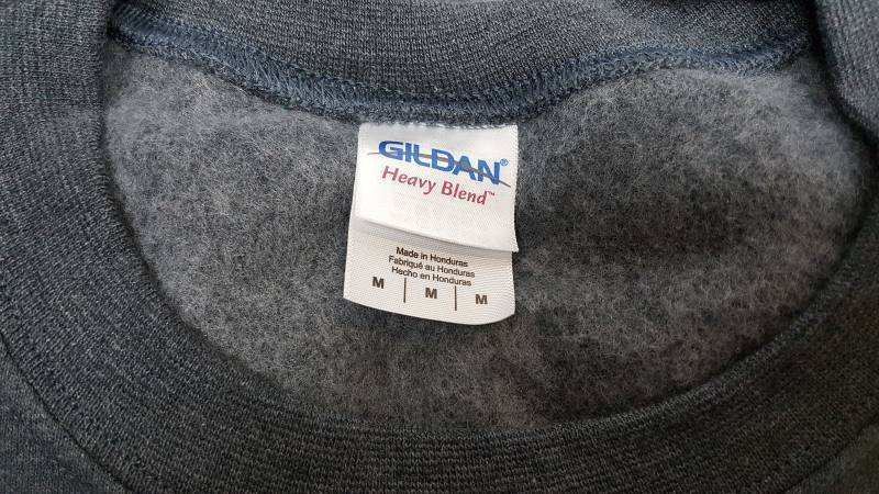 lot 7011-3 image: New in the package is this Dark Heather color is this Gildan Heavy Blend Crewneck Cozy Sweat shirt size M
