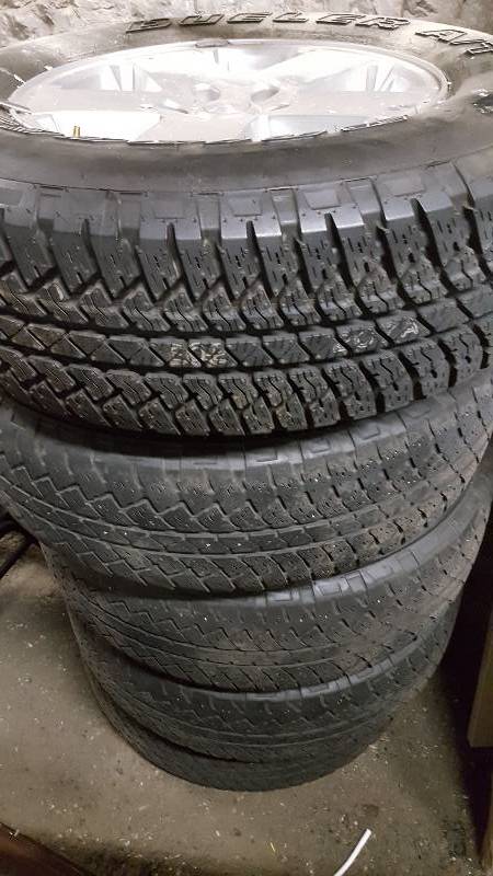 lot 5232 image: Stack of 5 Jeep tires and alloy factory wheels.  The top tire is brand spankin new and size 25570R18