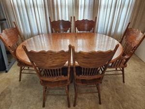 lot 21 image: Solid Oak Dining Table with Leaf and (6) Chairs (2 are captains chairs) (48x71x30 with leaf and 48x30 round)