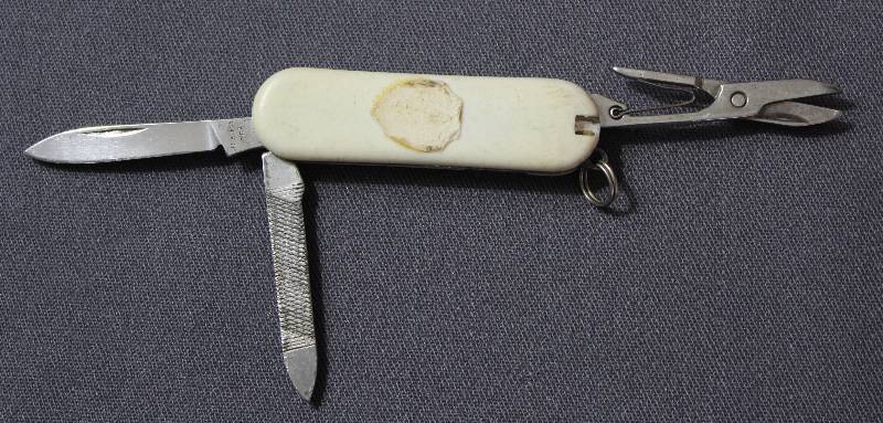 lot 9063 image: Vintage 2.25 White Plastic Folding Multi-Tool Pocket Knife with Key Ring.