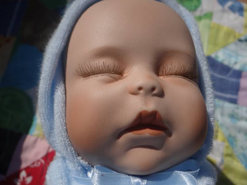 lot 758 image: Sleeping baby porcelain doll in basket.