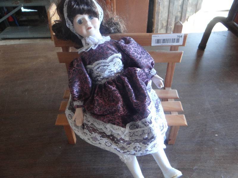 lot 764 image: Vintage porcelain doll on wooden bench.