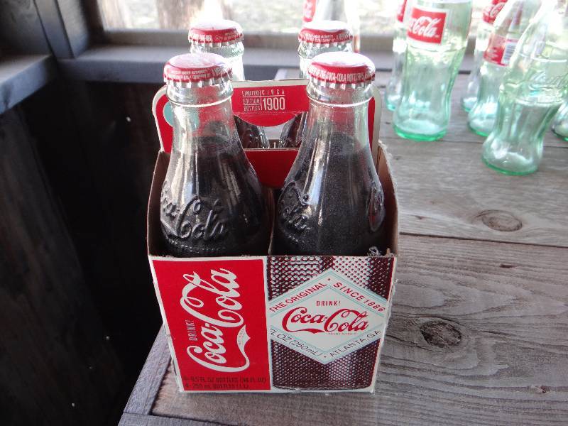 lot 956 image: 4 pack of Coca Cola bottles.