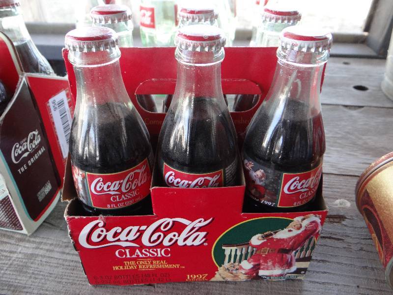 lot 957 image: 6 pack of Coca Cola bottles.