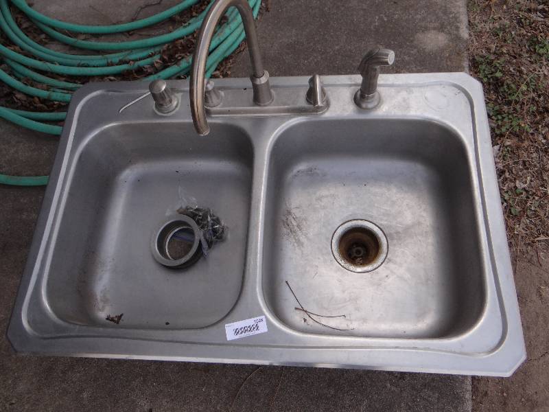 lot 1028 image: Stainless steel sink with faucet and soap dispenser.