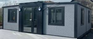 lot 107 image: Unused - Premier Upgraded Foldable Mini Home 20ftx20ft Model 0206 Gray Cladding w Two (2) Bedrooms, One (1) Bathroom w Toilet, Sink & Shower and Kitchen with Cabinets Retails Over $50,000