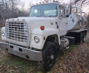 lot 130 image: Ford 9000 Tandem Axle Water Truck w Cummins Diesel & Eaton Fuller 13 Speed, Air Brakes, PTO, Brake Controller, 14ft x 96in BedTank-Top Fill w Rear Spray Bar & Rear Drain Outlet 52k GVWR RunsWorks Great This Was Needed By Many Last Summer
