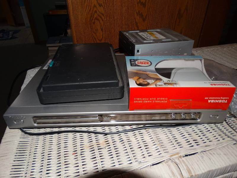 lot 390 image: Philips DVD Player, Samsung Portable DVD Player, Toshiba Portable Hard Drive in Box, DVDCD Carry Case, & 7 Sony DVD-RWs in Cases.