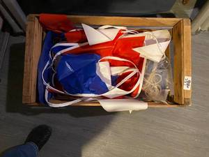 lot 289 image: Back yard fun Wooden crate with large strand of patriotic flags. Badminton net, flag football, and corn hole set