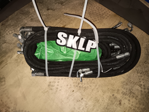 lot 1423 image: Unused SKLP Hydraulic Hose Bundle - Unused Bundle of High Pressure Hydraulic Hoses with Metal Fittings. Features Multiple 14 UP60MP2702PSI Rated Black Hydraulic Hoses.