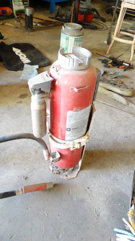 lot 3038 image: Ansul Fire extinguisher with wall mount and ratchet strap.