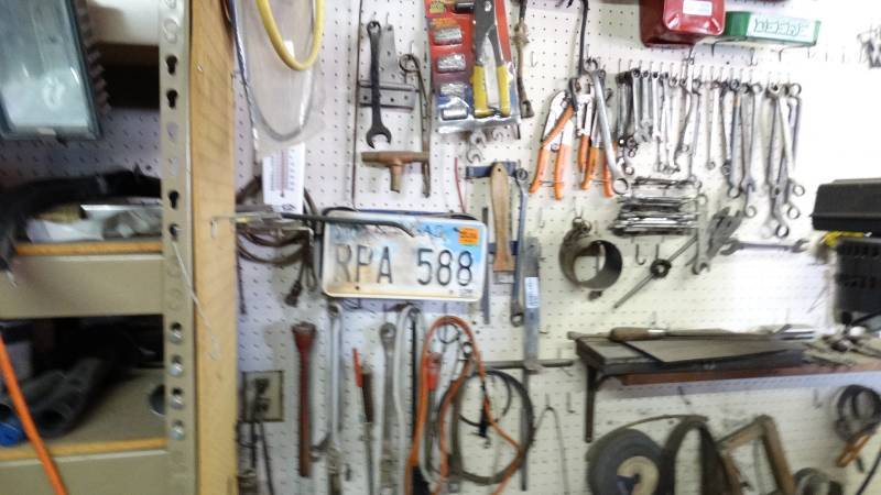 lot 3082 image: Wrenches, license plates, nut driver set, grinding wheels, hand riviter set, and oil filter wrenches and other hand tools.