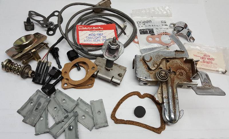 lot 6508 image: Big assortment of stuff here.  I dont recognize most of it but theres a 1957 Chevrolet hood latch