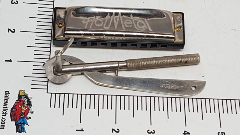 lot 6488 image: I know what the harmonica is but no clue what the other stainless steel tool or device is