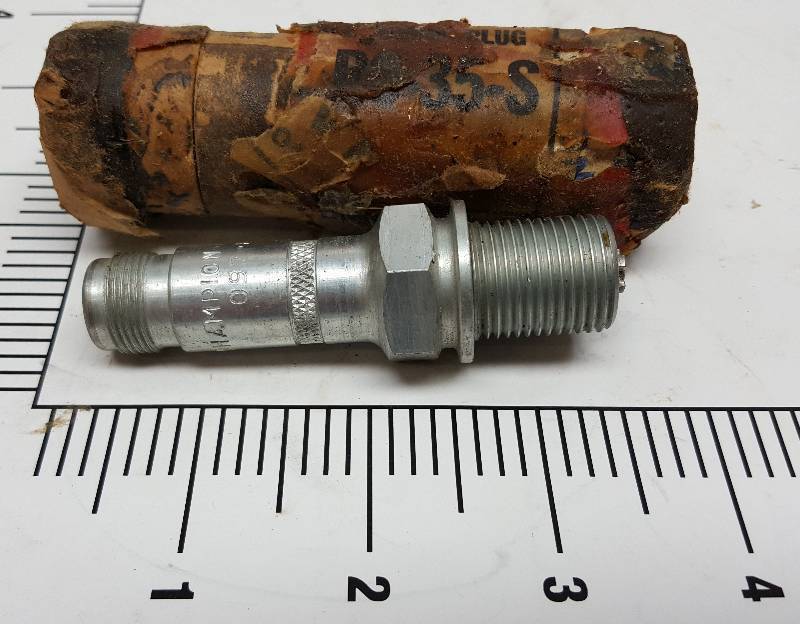 lot 5565 image: Its new but real old is this Collectable Champion military or Warbird prop job air plane spark plug with the tube used to store it in for many years.