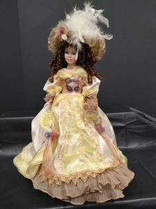 lot 488 image: Porcelain Doll in Victorian Yellow Dress with Feathered Hat, Includes Original Manufactures Tag, Stands 24 Inches Tall