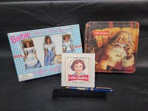 lot 27 image: Little Debbie Collectible Set - Barbie Dolls, Tin, Pen and Coaster
