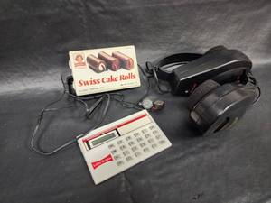 lot 29 image: Little Debbie Promotional Items - Calculator, Headphones, Swiss Cake Rolls Box