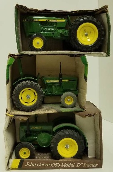 lot 1023 image: 3 each ERTL John Deere Tractors -Utility Tractor, 116 scale, # 516 Compact Utility Tractor, 116 scale, #581  1953 Model D Tractor, 116 scale, # 5596. NIB but Tractors dusty and box weathered
