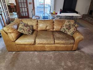 lot 30 image: Amazingly Comfortable Sealy Tan Leather Sofa with Floral Accent Pillows- Just need leather cleaner and conditioner- 89in