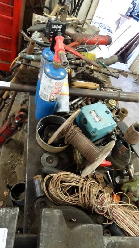 lot 1912 image: Contents of work table, scrap metal, blow torches, wire, chain, other hardware.