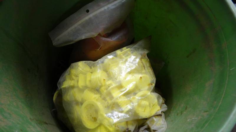 lot 5130 image: Bucket of electric fence post insulators.