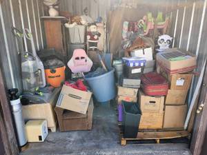 lot 1 image: 10X10 unit. Appears to have furniture, household items, vacuums, holiday items, and more