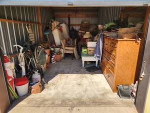 lot 2 image: 10X20 unit. Appears to have furniture, planters, holiday items, boxes, and bags