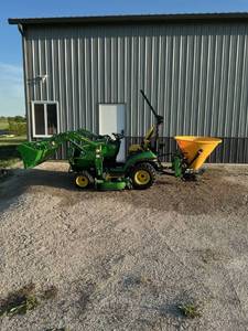 lot 47862 image: John Deere 1025R Tractor ALMOST New (less than 120 hours) with 120R Loader, 60 inch Mower Deck & Frontier Broadcast Spreader