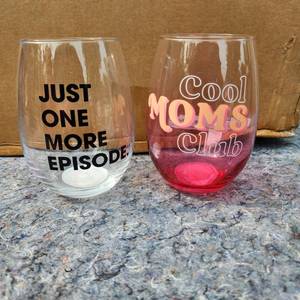 lot 345 image: CASE OF 18 - Novelty Stemless Wine Glass Set - Just One More Episode & Cool Moms Club