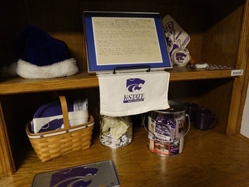 lot 266 image: 2 shelves of K-State decor. License plate, cups, santa cap and misc