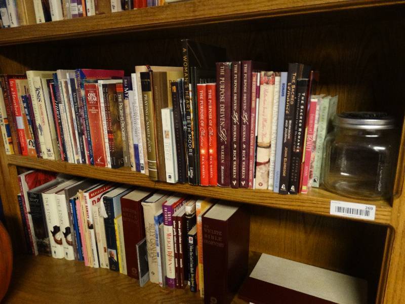 lot 269 image: 2 shelves of books and a jar with a K-State emblem on lid.