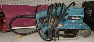 lot 3464 image: Makita 9903 Belt Sander 3x21in 120V  8.8 AMP motor with electronic speed control to maintain constant speed under load - Variable Speed Control Dial -Features less noise at only 84dB, it is one of the quietest sanders in its class.