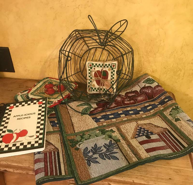 lot 1005 image: Apple-icious Recipe Book and Dcor items (wire basket, cloth coasters, table runner 13 x 70, and hot pads