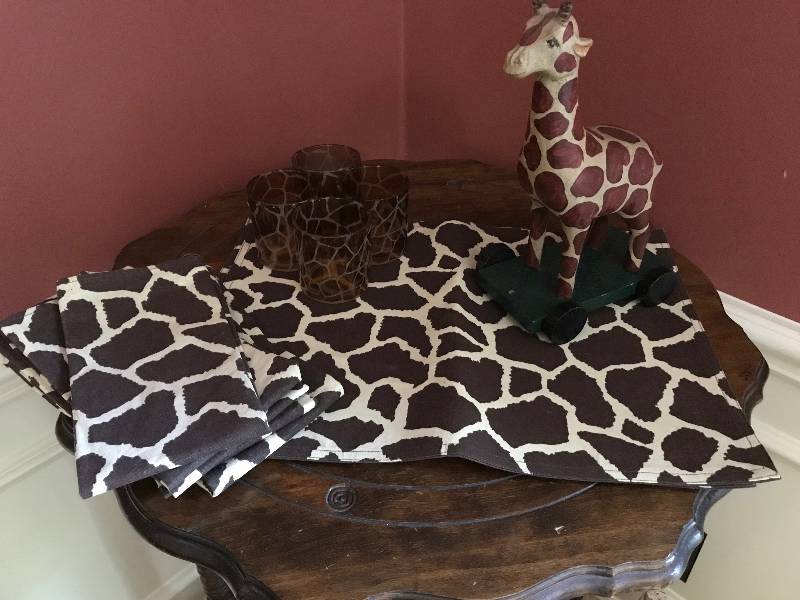 lot 1033 image: Wooden Giraffe on wheels along with placemats, napkins and candle holders