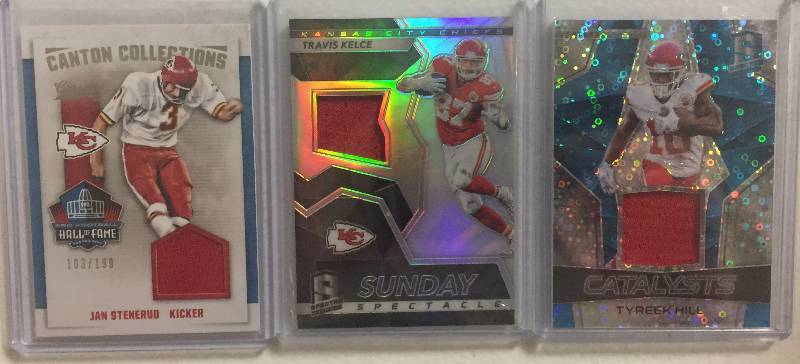 lot 1282 image: Three Kansas City Chiefs Player Worn Jersey Relic Football Cards - Travis Kelce, Jan Stenerud, & Tyreek Hill