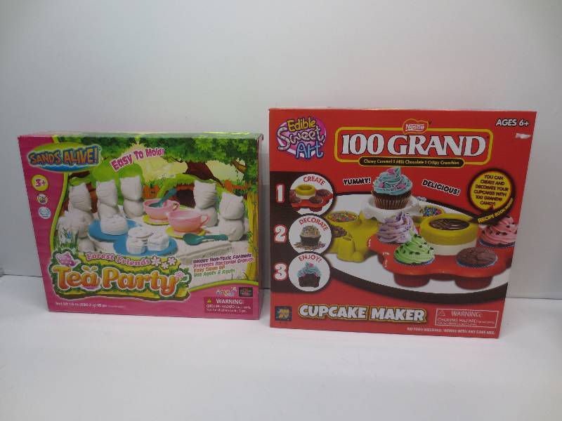 lot 1255 image: Lot of 2, nestle 100 grand cupcake maker and sands alive tea party